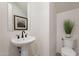 Stylish powder room with a pedestal sink, modern faucet, and decorative mirror at 2121 W Sonoran Desert Dr # 41, Phoenix, AZ 85085