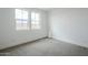 Bright bedroom with neutral carpet, white walls, and two windows, making it an inviting space at 21250 E Sparrow Dr, Queen Creek, AZ 85142