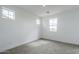 A bright bedroom with neutral carpet, white walls and large windows at 21250 E Sparrow Dr, Queen Creek, AZ 85142