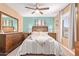 Stylish bedroom with light turquoise accent wall, featuring a comfortable bed, natural light, and furniture at 2331 E Evans Dr, Phoenix, AZ 85022