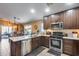 Modern kitchen with stainless steel appliances, dark wood cabinetry, and granite countertops at 24204 N 27Th Pl, Phoenix, AZ 85024