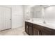 Bathroom features a dual sink vanity with modern fixtures and a large mirror at 25179 W Atlanta Ave, Buckeye, AZ 85326