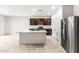 Modern kitchen featuring stainless steel appliances, a center island, and dark wood cabinetry at 25179 W Atlanta Ave, Buckeye, AZ 85326