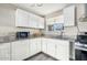 Bright kitchen with granite countertops, white cabinetry, stainless steel sink, and modern appliances at 2812 W Heatherbrae Dr, Phoenix, AZ 85017