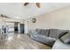 Comfortable living room featuring modern gray sofa, wood-look flooring, and seamless flow into the updated kitchen at 2812 W Heatherbrae Dr, Phoenix, AZ 85017