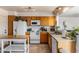 Well-lit kitchen with oak cabinets, white appliances, tile floors and a moveable prep island at 3031 S Los Altos --, Mesa, AZ 85202