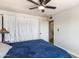 Serene main bedroom with white curtains, ceiling fan, and a glimpse into the ensuite bathroom at 3031 S Los Altos --, Mesa, AZ 85202