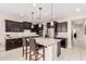 Modern kitchen featuring granite countertops, stainless steel appliances, dark cabinetry, and an island with seating at 30816 N 138Th Ave, Peoria, AZ 85383