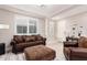 Inviting living room featuring a plush sofa, patterned ottoman, and shuttered windows at 30816 N 138Th Ave, Peoria, AZ 85383