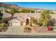 Aerial view of the house with a three car garage, mature landscaping and mountains in the background at 3144 E Desert Broom Way, Phoenix, AZ 85048