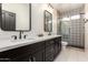 Modern bathroom with dual sinks, quartz countertop, and sleek glass shower with decorative tile at 3144 E Desert Broom Way, Phoenix, AZ 85048