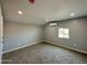 A neutral-toned bedroom featuring plush carpeting, smooth walls, and climate control via a ductless air conditioner at 318 E Hill Dr, Avondale, AZ 85323