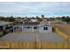 Single story home with gravel yard, solar panels, and a light-colored fence at 318 E Hill Dr, Avondale, AZ 85323