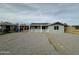 Single story home with a light grey exterior, solar panels and gravel landscaping at 318 E Hill Dr, Avondale, AZ 85323