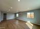 Open-concept living room with wood floors, recessed lighting, and multiple windows at 318 E Hill Dr, Avondale, AZ 85323