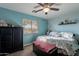 Inviting bedroom with soothing blue walls, comfortable bed, ceiling fan, and natural light at 34734 N Happy Jack Dr, San Tan Valley, AZ 85144