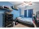 Comfortable bedroom with blue accent wall, a ceiling fan, and dark wood furniture at 34734 N Happy Jack Dr, San Tan Valley, AZ 85144