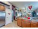 Bright kitchen featuring tile flooring, wooden cabinetry, and an open view to the living area at 34734 N Happy Jack Dr, San Tan Valley, AZ 85144