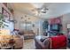 Comfortable living room featuring a vaulted ceiling, ceiling fan, tile flooring, and neutral-toned furniture at 34734 N Happy Jack Dr, San Tan Valley, AZ 85144