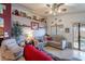 Comfortable living room showcasing neutral tones, large sectional, ceiling fan, and decorative shelving at 34734 N Happy Jack Dr, San Tan Valley, AZ 85144