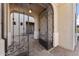 View from the ornate, arched courtyard gate towards the home's entrance at 3557 S Halsted Ct, Chandler, AZ 85286