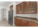 A butlers pantry with granite countertops, brown cabinets and stainless steel appliances at 3557 S Halsted Ct, Chandler, AZ 85286