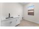 Laundry room with sink, storage cabinets, and tile flooring at 3557 S Halsted Ct, Chandler, AZ 85286