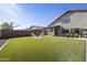 Large backyard with lush artificial grass, a cozy fire pit, and comfortable seating for relaxation at 4439 E Coyote Wash Dr, Cave Creek, AZ 85331
