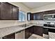 Modern kitchen featuring stainless steel appliances, granite countertops, and dark brown cabinetry at 454 N 19Th Pl, Coolidge, AZ 85128