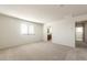 Spacious carpeted bedroom with natural light, neutral color palette, and an attached bathroom at 5055 S 251St Dr, Buckeye, AZ 85326