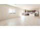 Open-concept living area with a view of the modern kitchen featuring stainless steel appliances and dark cabinets at 5055 S 251St Dr, Buckeye, AZ 85326