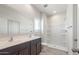 Bright bathroom featuring dual sinks, a walk-in shower, and modern fixtures at 5073 S 251St Dr, Buckeye, AZ 85326