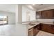 Open kitchen with granite countertops and dark cabinets flows seamlessly into the adjacent living space at 5073 S 251St Dr, Buckeye, AZ 85326