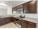 Modern kitchen with granite countertops, stainless steel appliances, and dark cabinets at 5073 S 251St Dr, Buckeye, AZ 85326