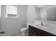 Bathroom featuring a dark vanity, toilet, and a large mirror, with natural light from the window at 5080 S 251St Dr, Buckeye, AZ 85326