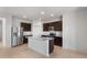 Bright kitchen showcasing stainless steel appliances, island with sink, and dark wood cabinets at 5080 S 251St Dr, Buckeye, AZ 85326