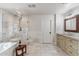 Bright bathroom features a soaking tub and a glass enclosed shower with marble tile at 5201 N 33Rd St, Phoenix, AZ 85018