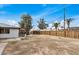 Spacious backyard with a tall wooden fence, mature trees, and room for outdoor activities at 5902 W Wolf St, Phoenix, AZ 85033