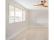 Light-filled bedroom featuring tile floors, a modern fan, and a large window showcasing exterior views at 5902 W Wolf St, Phoenix, AZ 85033