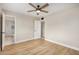 This bedroom has wood-look floors, a ceiling fan, and an attached bath at 5902 W Wolf St, Phoenix, AZ 85033