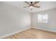 Cozy bedroom featuring wood-look flooring, a ceiling fan, and a window at 5902 W Wolf St, Phoenix, AZ 85033