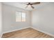 Bright bedroom features wood-look flooring, a ceiling fan, and natural light from the window at 5902 W Wolf St, Phoenix, AZ 85033