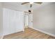 Bedroom showcasing closet, neutral paint, wood-look flooring, and a ceiling fan at 5902 W Wolf St, Phoenix, AZ 85033