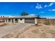 Inviting single-story home with attached garage, xeriscaped yard, and a vibrant turquoise-colored front door at 5902 W Wolf St, Phoenix, AZ 85033