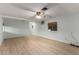 Spacious living room featuring neutral walls, a ceiling fan, and wood-look laminate flooring at 6830 W Mckinley St, Phoenix, AZ 85043