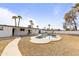 View of a backyard featuring a kidney-shaped pool, lounge chairs, palm trees, and white exterior at 718 W Vine Ave, Mesa, AZ 85210