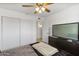 Bedroom with large wardrobe, ceiling fan, and modern dresser with TV at 718 W Vine Ave, Mesa, AZ 85210