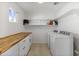 Well-lit laundry room with butcher block countertop, white cabinetry, and modern washer and dryer at 718 W Vine Ave, Mesa, AZ 85210