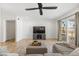 Bright living room with wood floors, a ceiling fan, a TV, and sliding glass doors to the backyard at 718 W Vine Ave, Mesa, AZ 85210