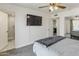 Main bedroom with a ceiling fan, a TV, and an open view into the attached bathroom at 718 W Vine Ave, Mesa, AZ 85210